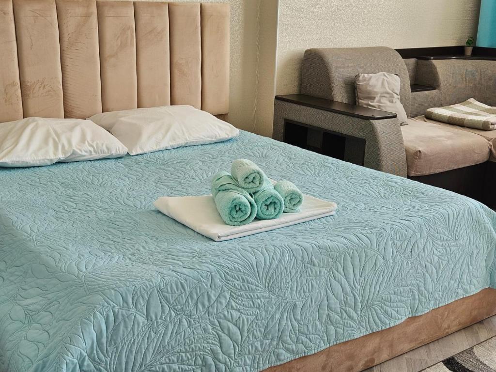 a bed with a tray with three towels on it at ЖК Edel 1ком квартира комфорт набережная проспект Сарыарка in Astana