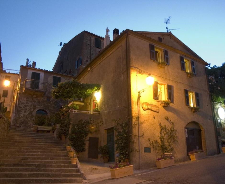 un vecchio edificio con scale in città di notte di Lo Sdrucciolo Affittacamere a Manciano