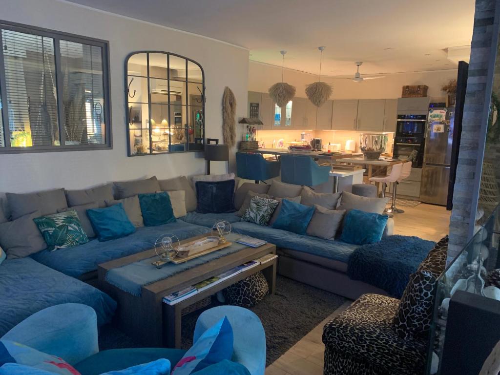 un salon avec un canapé bleu et une cuisine dans l'établissement Loft au cœur du golfe de st tropez, à Cogolin