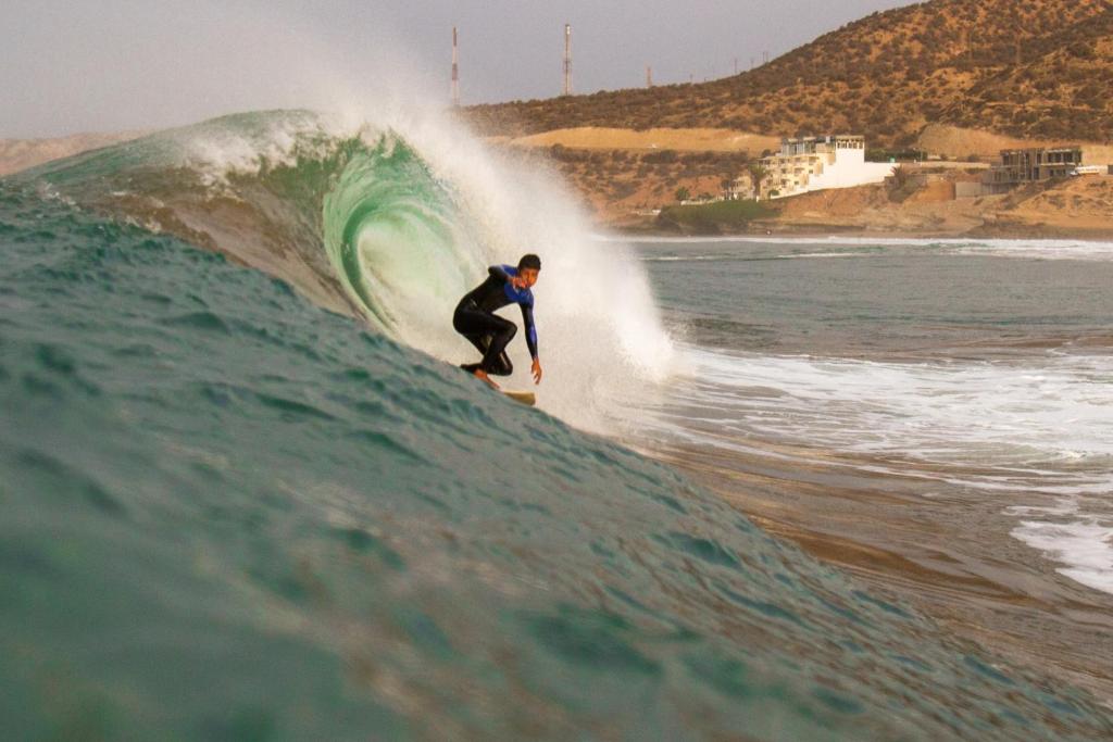 a man riding a wave on a surfboard in the ocean at Asklou in Taghazout