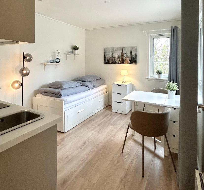 a bedroom with a bed and a desk and a table at Newly renovated studio apartment - free parking and EV docking in Trondheim