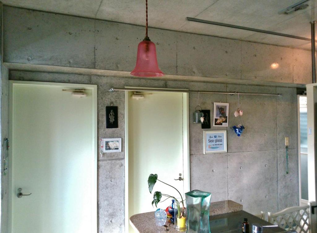 a kitchen with two white doors and a red light at Guesthouse Seaglass in Itoman