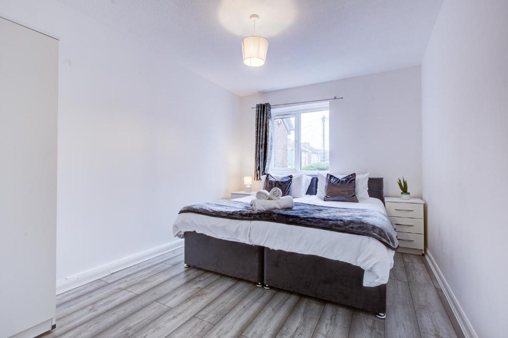 Un dormitorio blanco con una cama y una ventana. en Spacious 2 Bed Apartment South London, en Thornton Heath