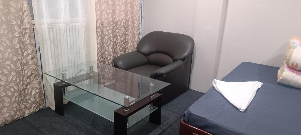a chair and a glass table in a room at Hillcrest Prapti Homestay in Darjeeling