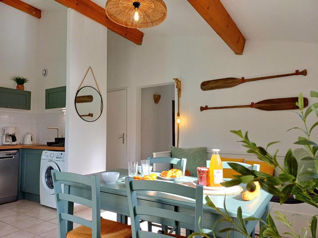 une cuisine et une salle à manger avec une table et des chaises dans l'établissement Ardèche Horizon, Appartement climatisé avec Terrasse, Piscine et Parking, à Vallon-Pont-dʼArc