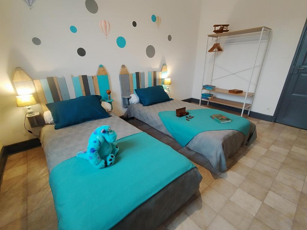 - une chambre avec 2 lits avec un ours en peluche dans l'établissement Le Sancy gîte Murol, à Murol