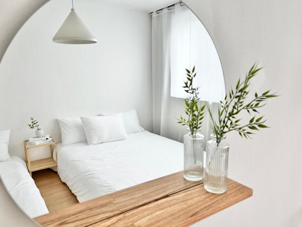ein weißes Schlafzimmer mit einem Bett und einem Spiegel in der Unterkunft Yeondam Stay in Seoul