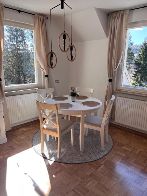 a dining room with a white table and chairs at Oaza Narave in Spodnje Gorje