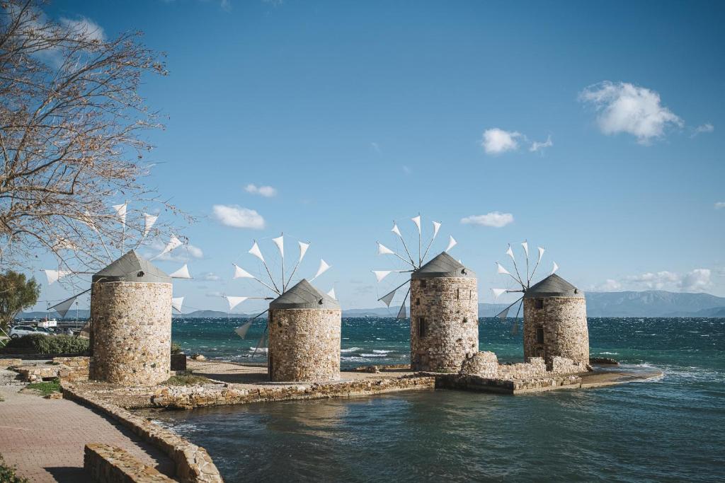 a row of stone windmills in the water at Millarakia House in Chios
