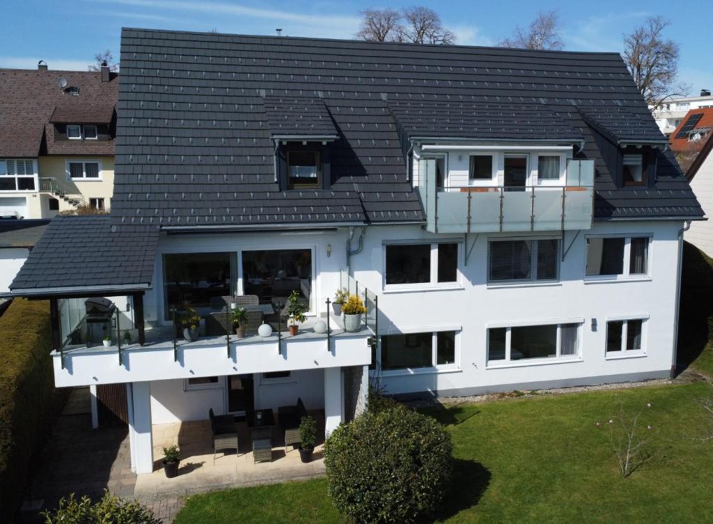 リンデンベルク・イム・アルゴイにあるFeWo Herz im Allgäu 2の黒い屋根の大きな白い家