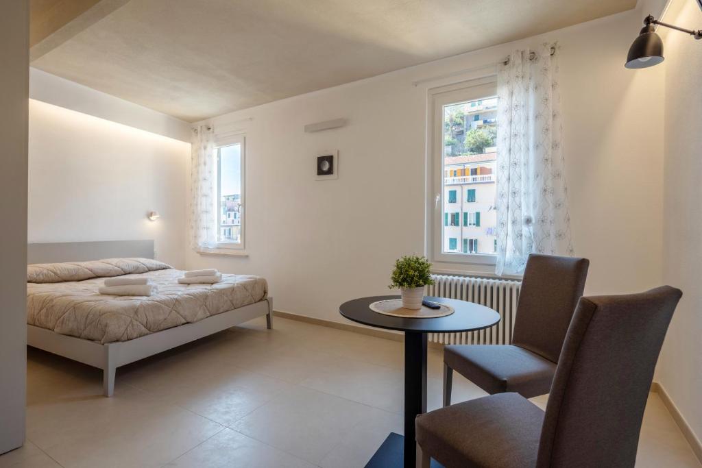 a bedroom with a bed and a table and a window at Locus Amoenus in Riomaggiore