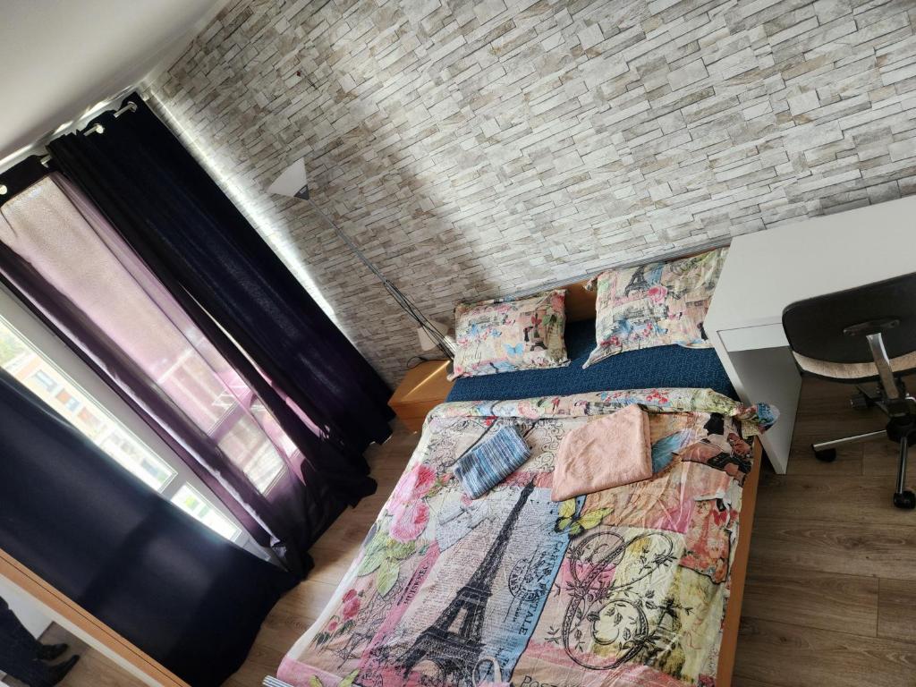 アティス・モンスにあるChambre privée près aéroport Paris Orlyのレンガの壁、ベッド2台が備わるベッドルーム1室が備わります。