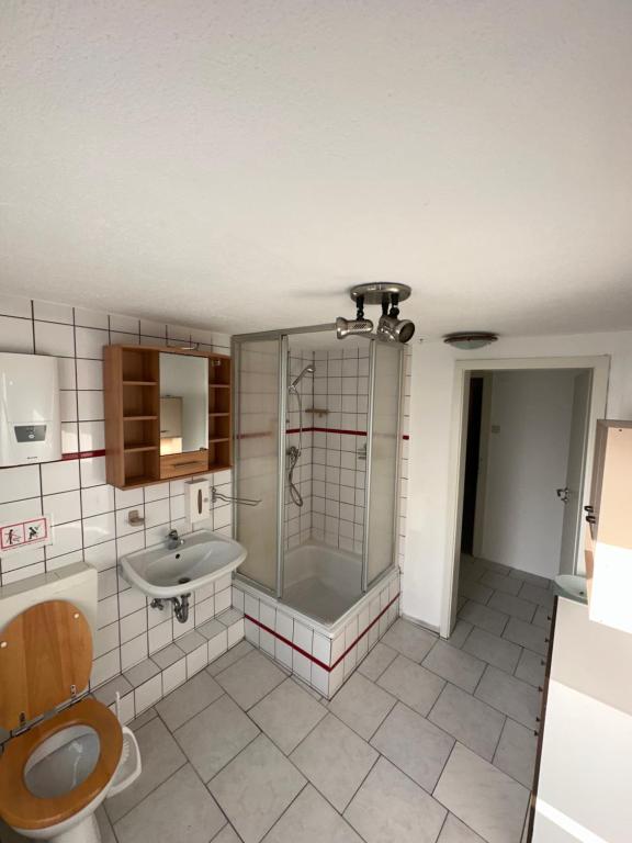 ein Badezimmer mit Dusche, Toilette und Waschbecken in der Unterkunft Cin Pension in Gronau