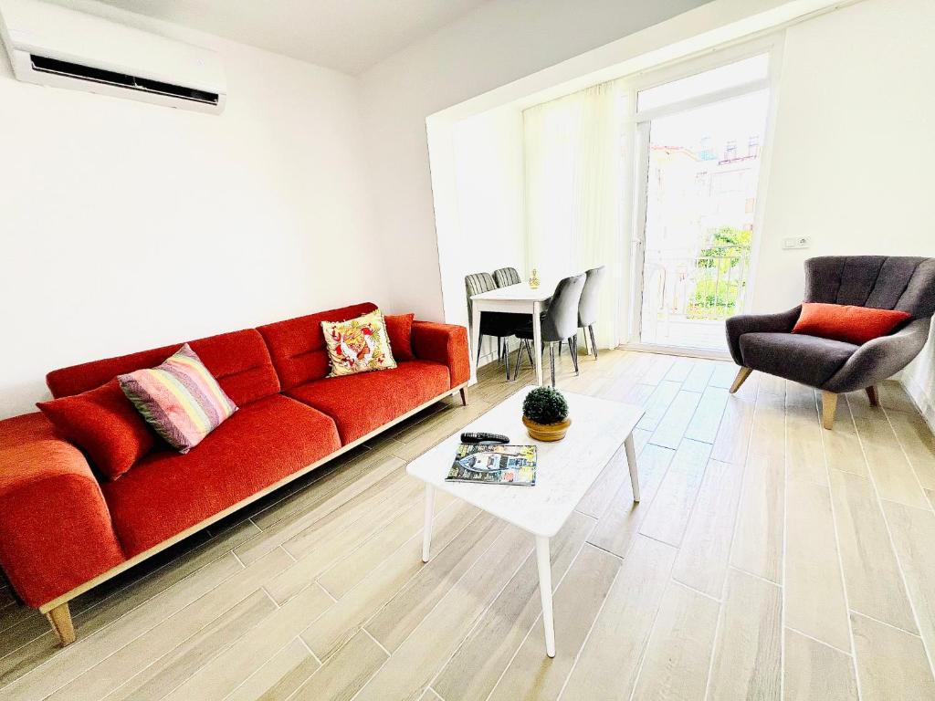 a living room with a red couch and a table at Alara loft in Antalya