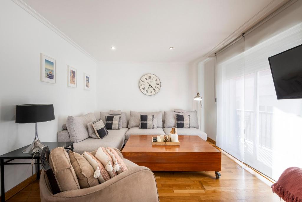 a white living room with a couch and a table at APARTAMENTO TURISTICO A 140 M PLAYA CANELIÑAS- Portonovo- 2 Habitaciones 5 pax 202 in Portonovo