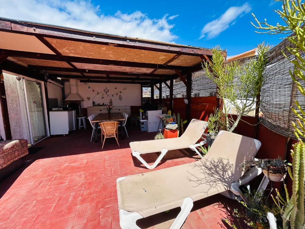 a patio with two white chairs and a table at Ático Sol Vecindario in Vecindario