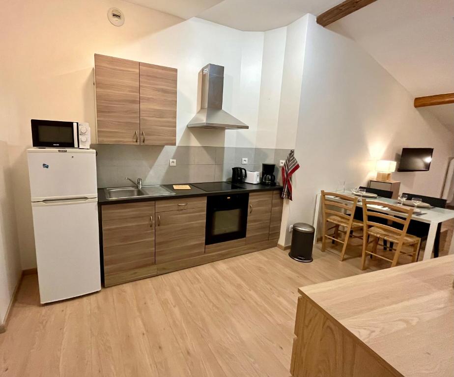 une cuisine avec un réfrigérateur blanc et une table dans l'établissement Magnifique appartement, au Puy-en-Velay