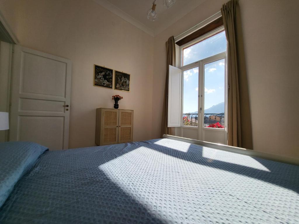 Un dormitorio con una cama grande con ventana. en Casa Bonita Guest House, en Salerno