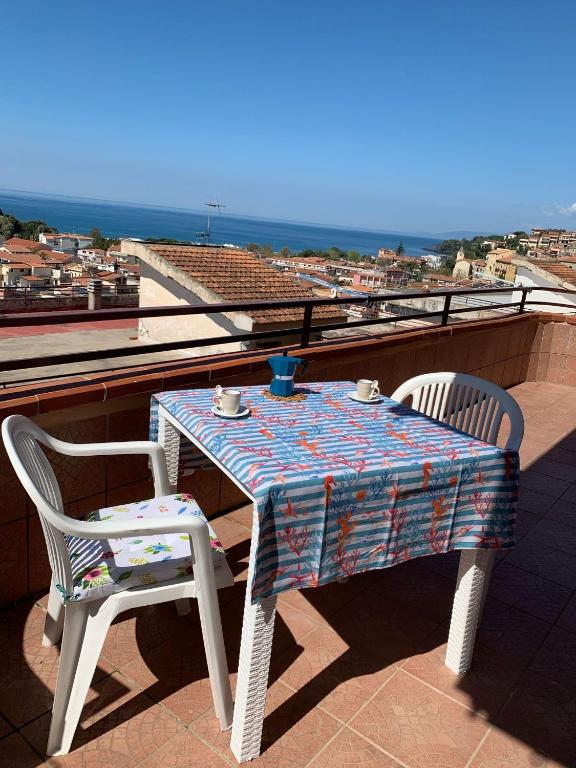 a table and two chairs sitting on a roof at Orizzonte Blu Holiday Home in Scalea