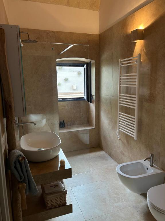 een badkamer met een wastafel, een toilet en een spiegel bij Lamia Al Mar in Torre Canne