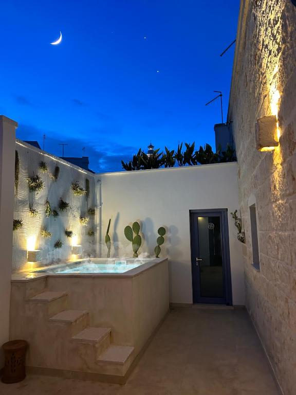 a bathroom with a hot tub with plants on the wall at Lamia Al Mar in Torre Canne