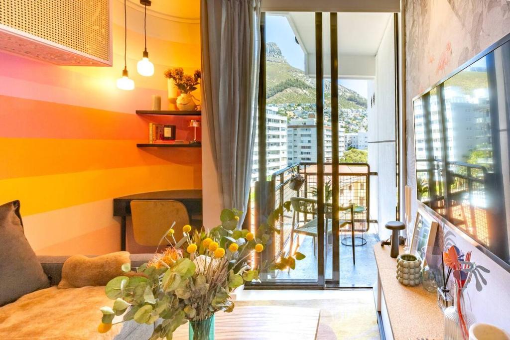 a living room with a vase of flowers on a table at Elegant Studio by the Sea in Cape Town
