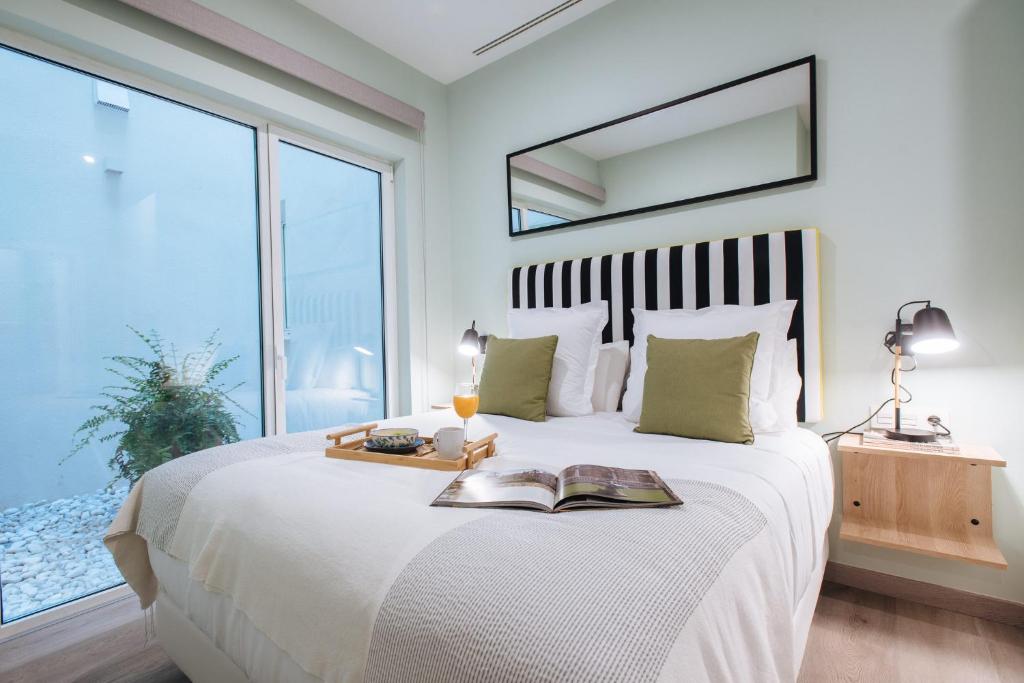 a bedroom with a large bed with a book on it at Sercotel Sevilla Guadalquivir Suites in Seville