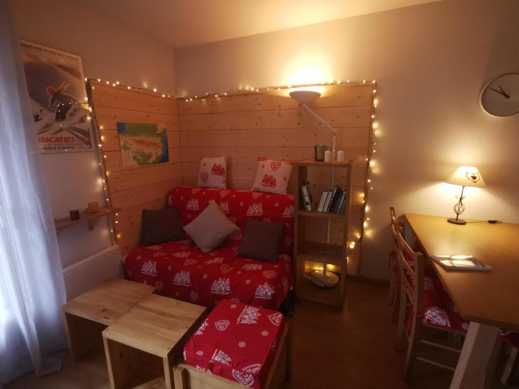 Cette chambre comprend un lit et une table éclairée. dans l'établissement T3 Cosy de plein pied Terrasse Jardin Luchon Pyrénées, à Luchon