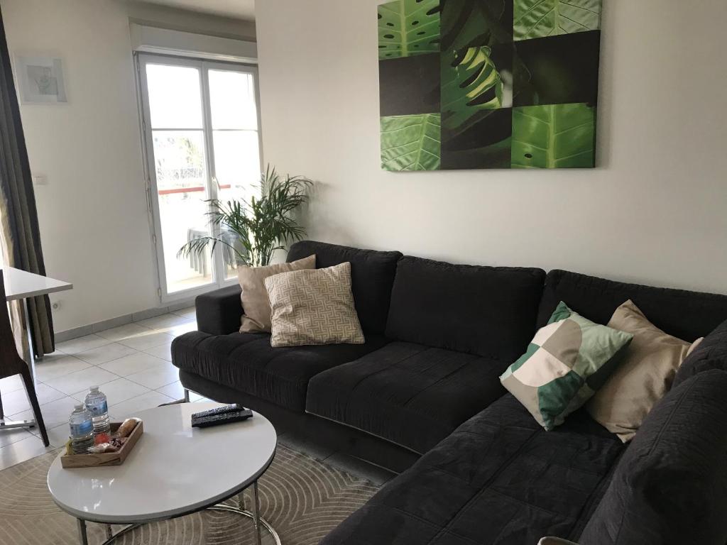 un salon avec un canapé noir et une table dans l'établissement 