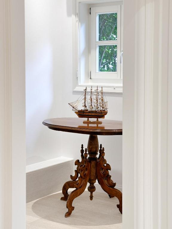 a wooden table with a model ship on it at Armata Boutique Hotel in Spetses