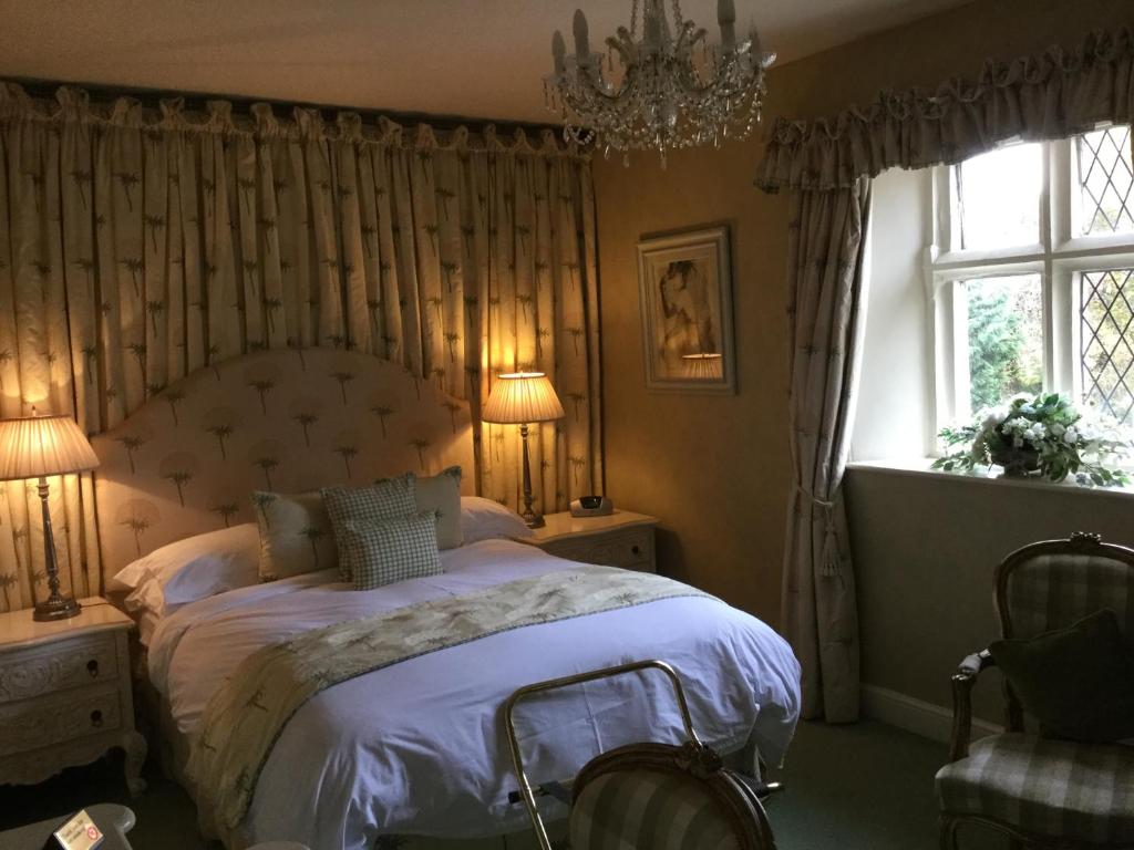 a bedroom with a bed and a chandelier and a window at The Brownlow Arms Inn in Grantham