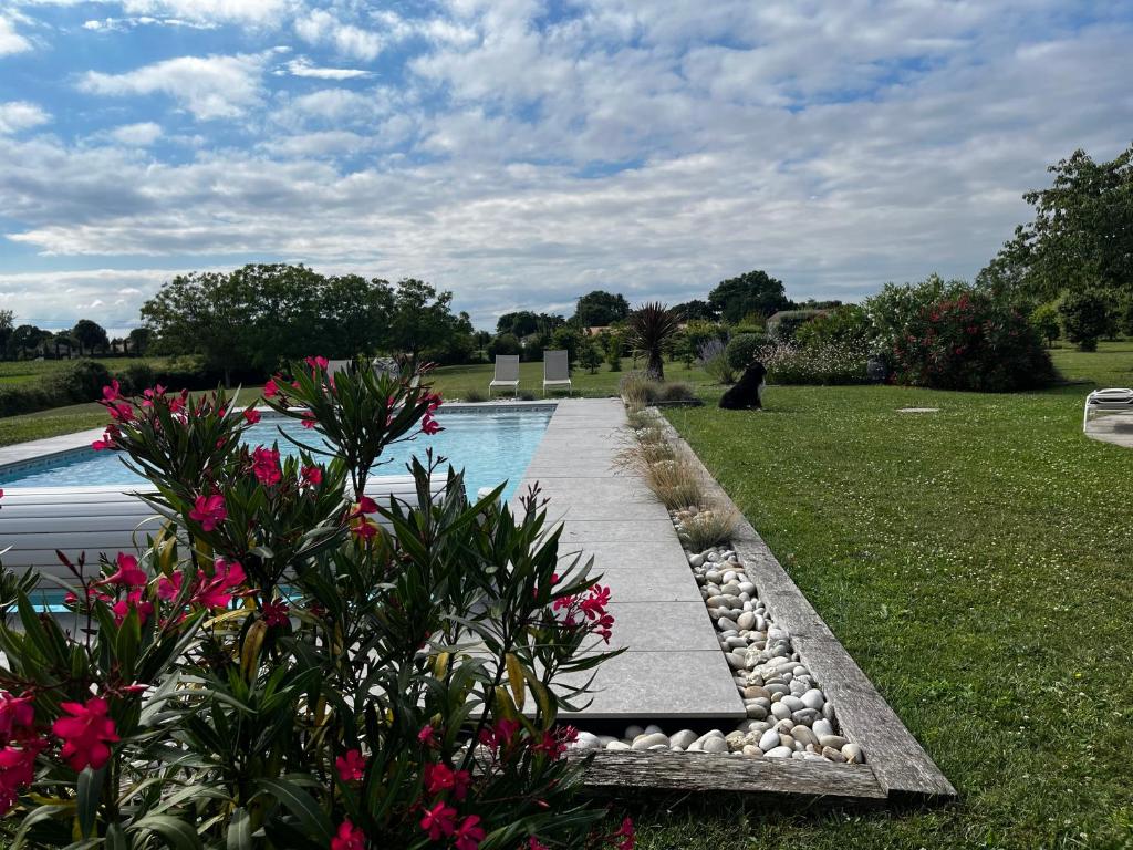 a garden with a swimming pool and some flowers at Le panorama de Canteloup in Fours