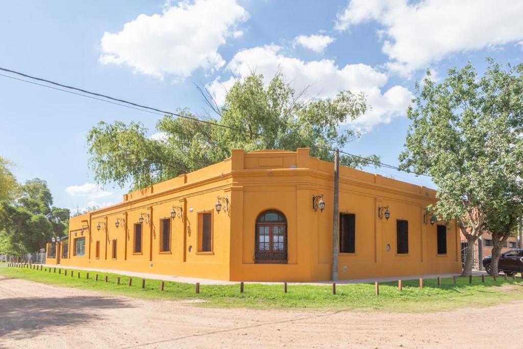 un edificio amarillo al costado de una calle en Como Entonces Casa, en Uribelarrea