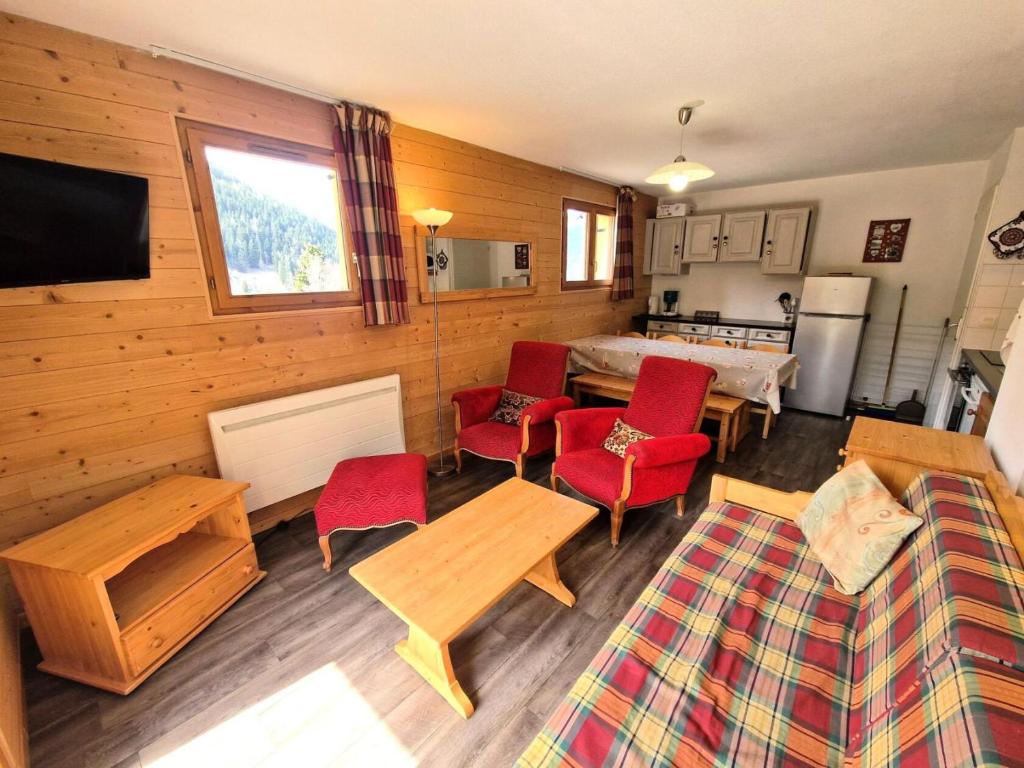 un salon avec des chaises rouges et un canapé dans l'établissement Les Chalets D'arrondaz - 4 pièces 6/8 personnes 48 m² MAE-2904, à Modane
