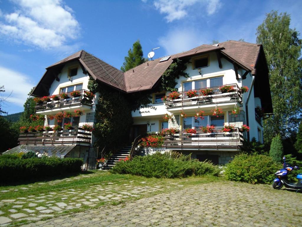 une maison avec des boîtes de fleurs à l'avant dans l'établissement Pension Dana, à Vrbno pod Pradědem