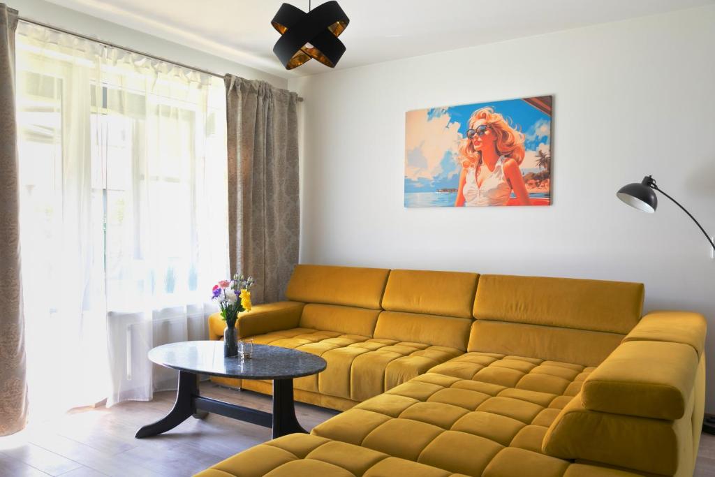 a living room with a yellow couch and a table at SOFAGOLD Nadštandardný apartmán s veľkou terasou in Košice
