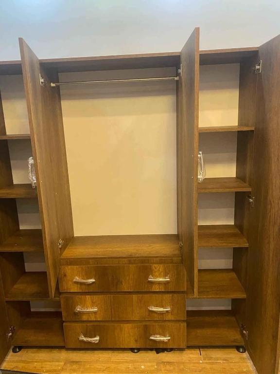 un placard vide avec des étagères et des armoires en bois dans l'établissement LINCON inn, à Aqaba