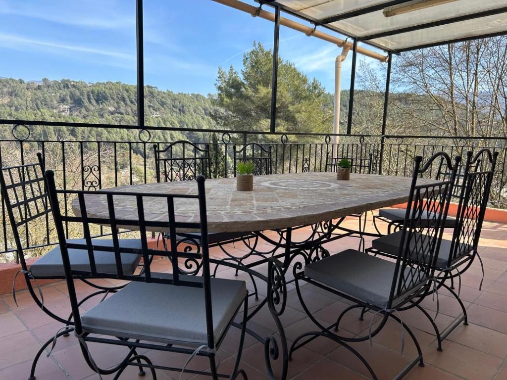 une table et des chaises sur une terrasse avec vue dans l'établissement Les 4 cyprès, à Contes