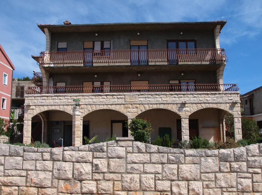 斯塔里格勒的住宿－Apartments Rade，一座位于石墙顶部的带阳台的建筑