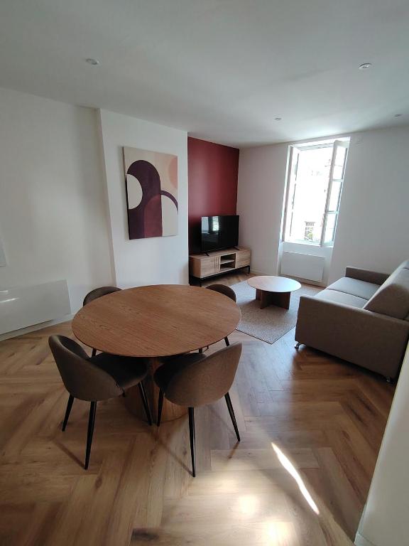 un salon avec une table, des chaises et un canapé dans l'établissement Le Gally 40m2 Cœur de ville avec garage!, à Rodez