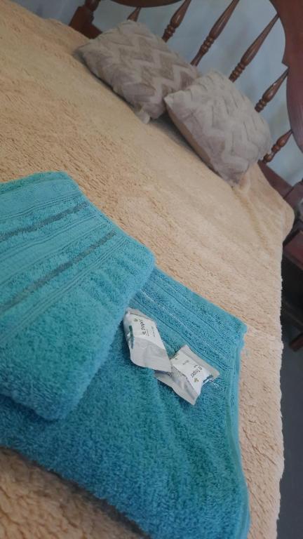 a blue blanket on a bed with a towel at Departamento in Termas de Río Hondo