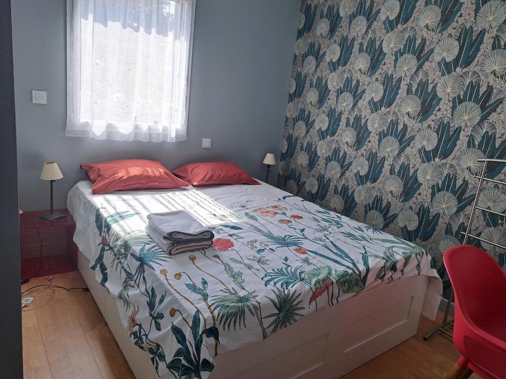 une chambre avec un lit avec un couvre-lit fleuri dans l'établissement Villa Joie, à La Turballe