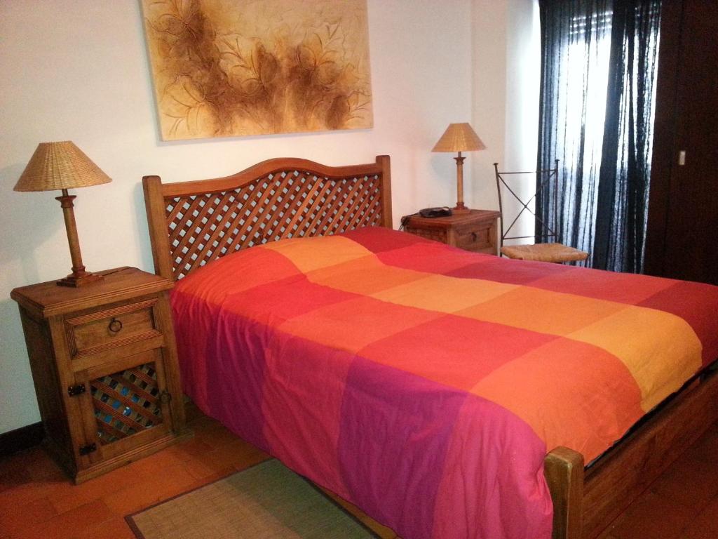 a bedroom with a colorful bed and two night stands at Armador Apartment in Armação de Pêra