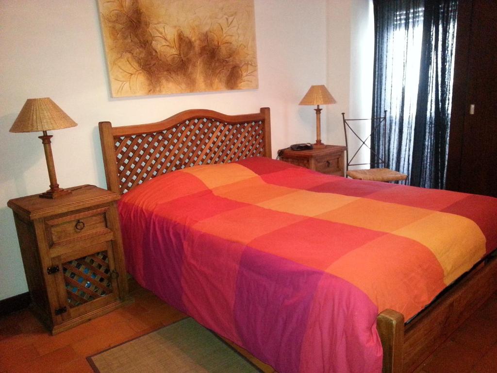 1 dormitorio con 1 cama colorida y 2 mesitas de noche en Armador Apartment, en Armação de Pêra