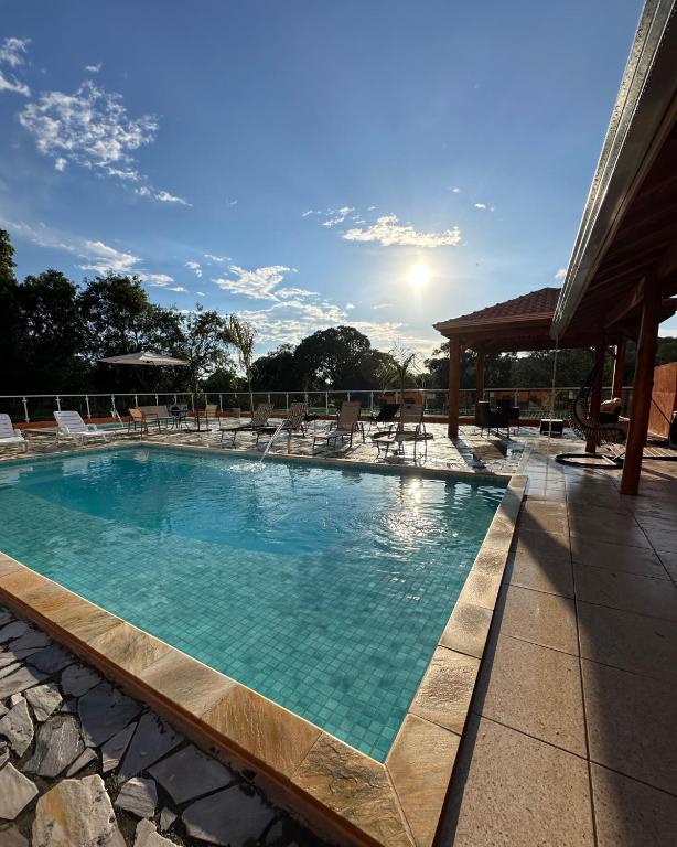 a large swimming pool with chairs and the sun at Espaço R&R 2 in São Roque