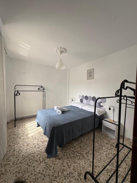 a bedroom with a bed with a blue blanket at Las Casas Del Puente in Córdoba