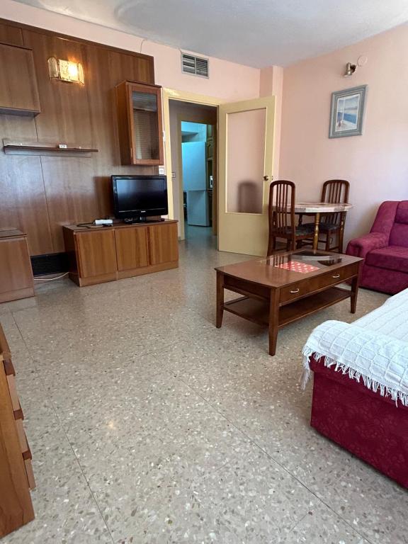 una sala de estar con un sofá y una mesa en CHUFLIS FLAt, en Argamasilla de Alba