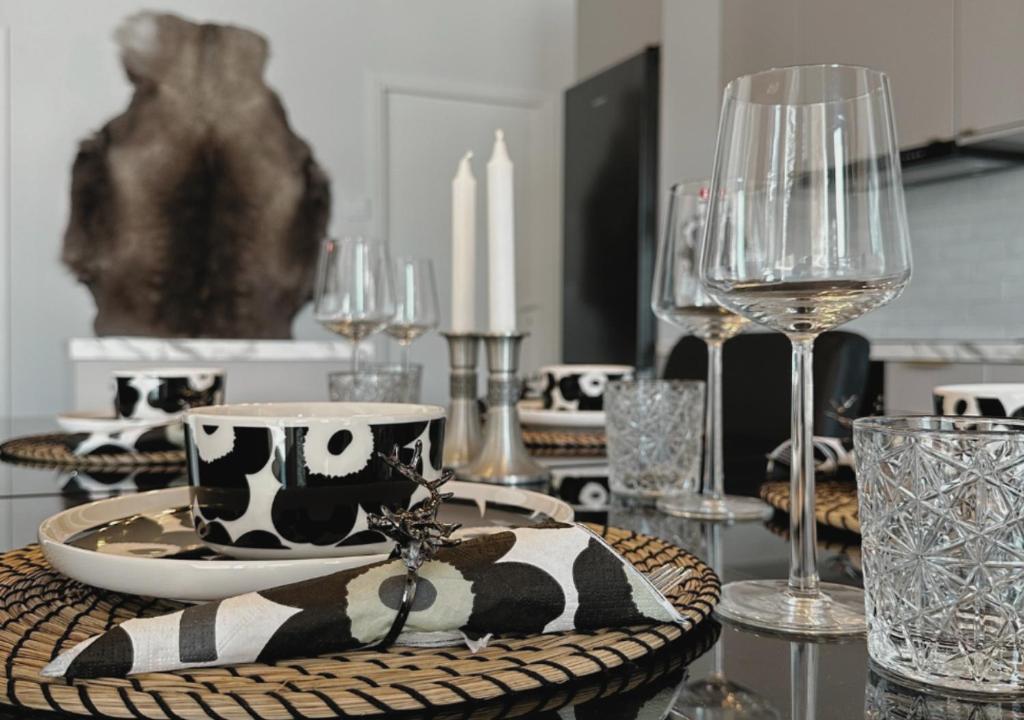 a dining room table with glasses and a table with a plate and a bowl at Luxeberry Villa Rovaniemi in Rovaniemi