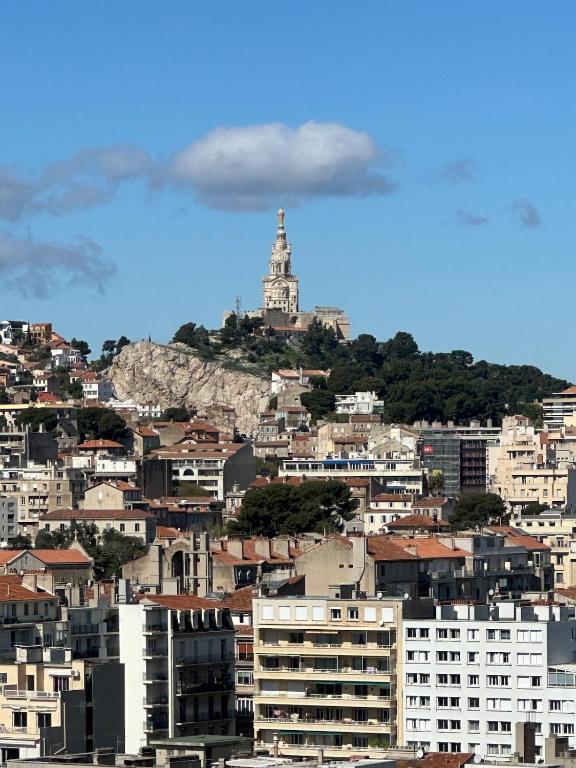 - une vue sur une ville avec un phare sur une colline dans l'établissement New apartment with panoramic view, à Marseille