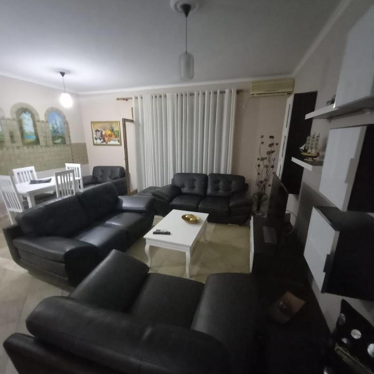 a living room with black couches and a table at Golden Apartment in Tirana